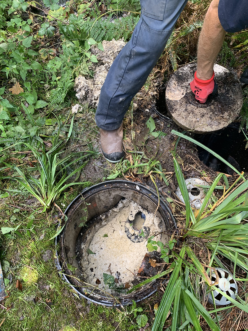 Lifting an inspection chamber cover to show the client the fat, grease and oil they are allowing to get into their treatment plant.