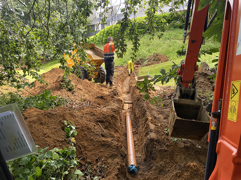 Trench digging to install the drainage soakaway for the rainwater runoff.