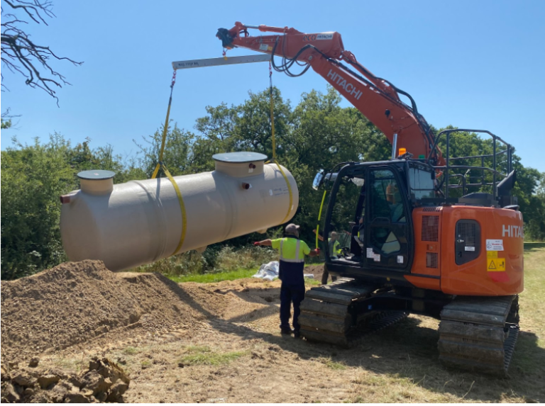 A 14 ton digger lifting up a 7metre treatment plant during an ASL installation of a private sewage system.