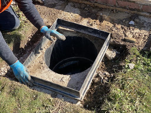This image shows ASL Limited fixing an inspection chamber/manhole after clearing the blocked drain beneath.