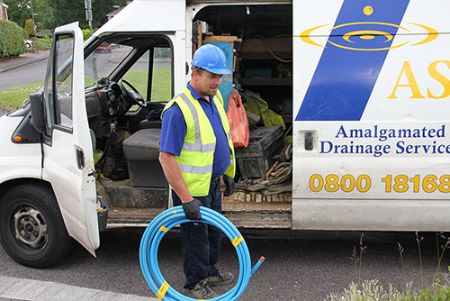 An image of one of ASL Limited water mains team and an ASL drainage van.