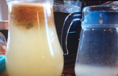 An example of fats and oils floating to the top in the left jug and the solids, in this case, broken down toilet paper, falling to the bottom in the right jug.