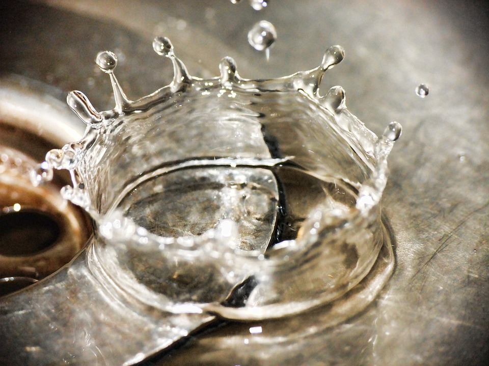 A photo of water splashing from a tap into the sink.