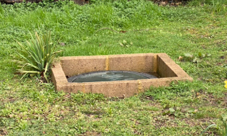 This image shows a treatment plant that has been put in the ground too deep and is attracting surface water. The brick surround is designed to combat this.