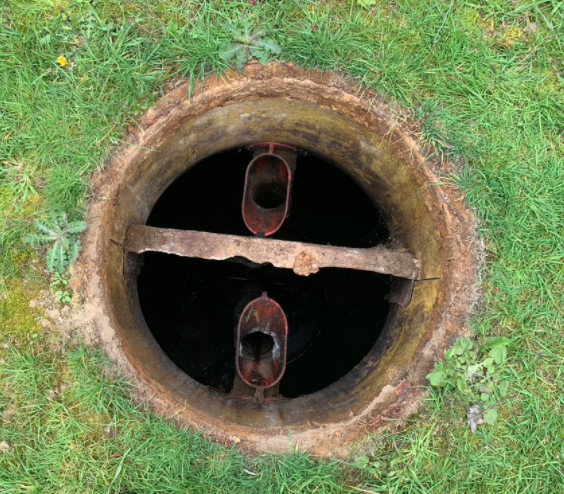 A septic tank with a concrete wall divide creating the two chambers.