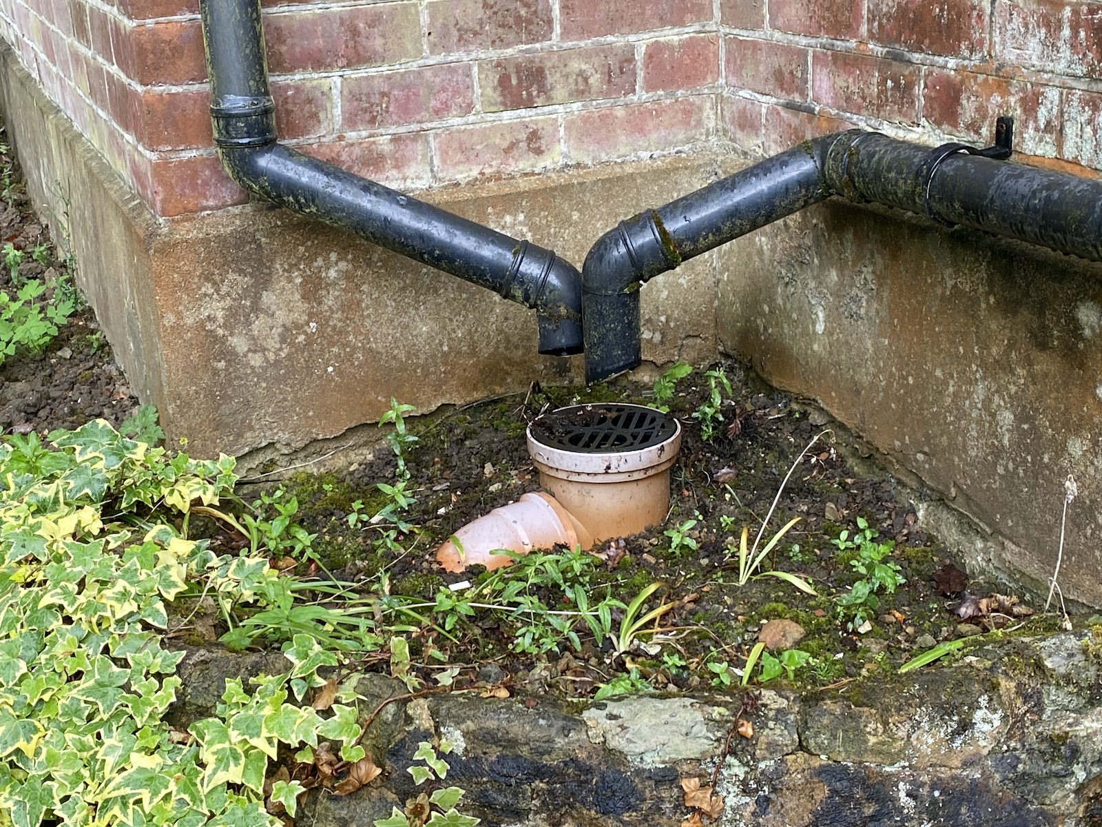 This image shows two surface water down pipe connections falling into a drain without the gully surround.