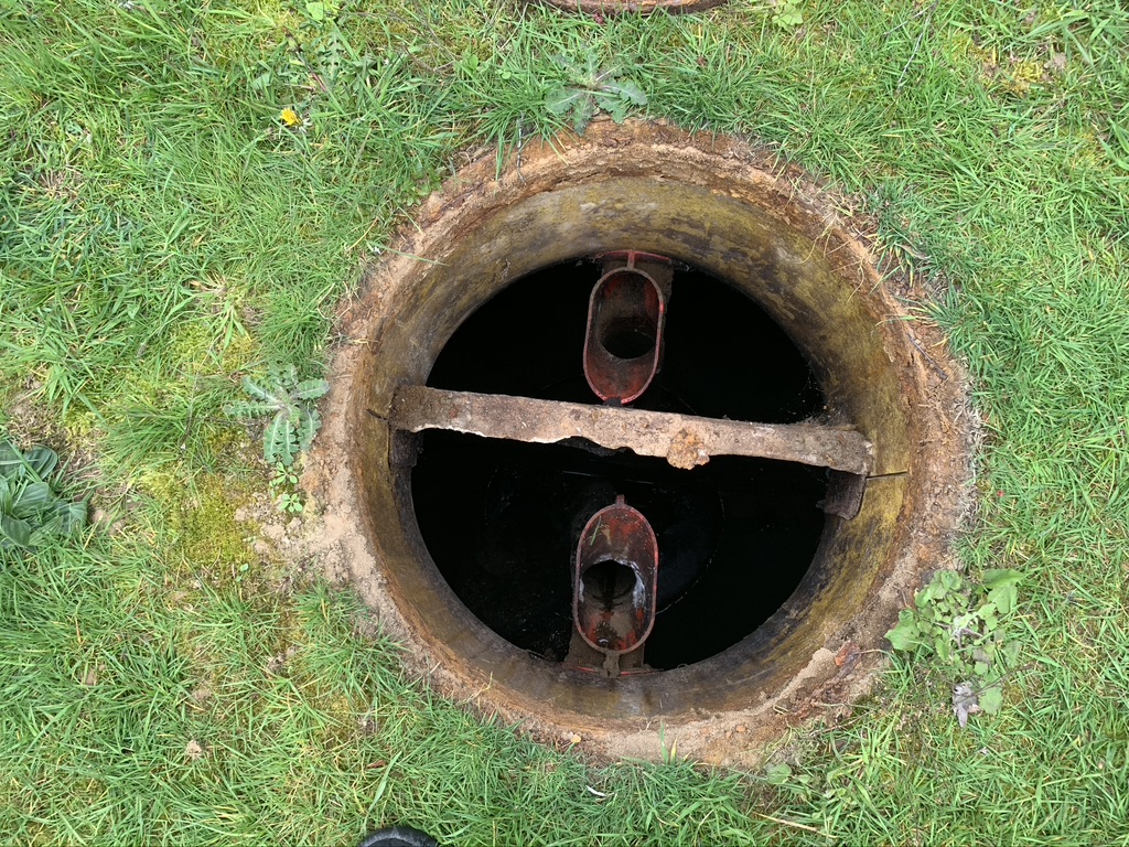 An image of an open septic tank utility hatch.