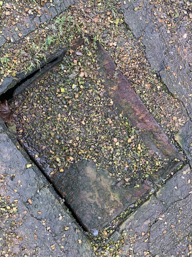 This is a photo of a manhole/inspection chamber cover that has been crushed by a lorry.