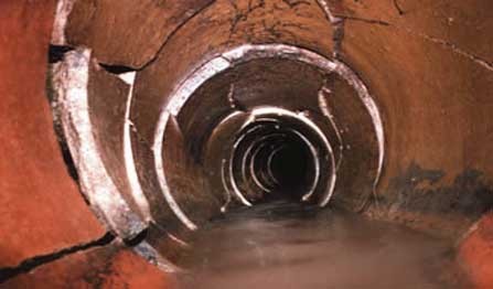 A photo of a broken drain pipe underground