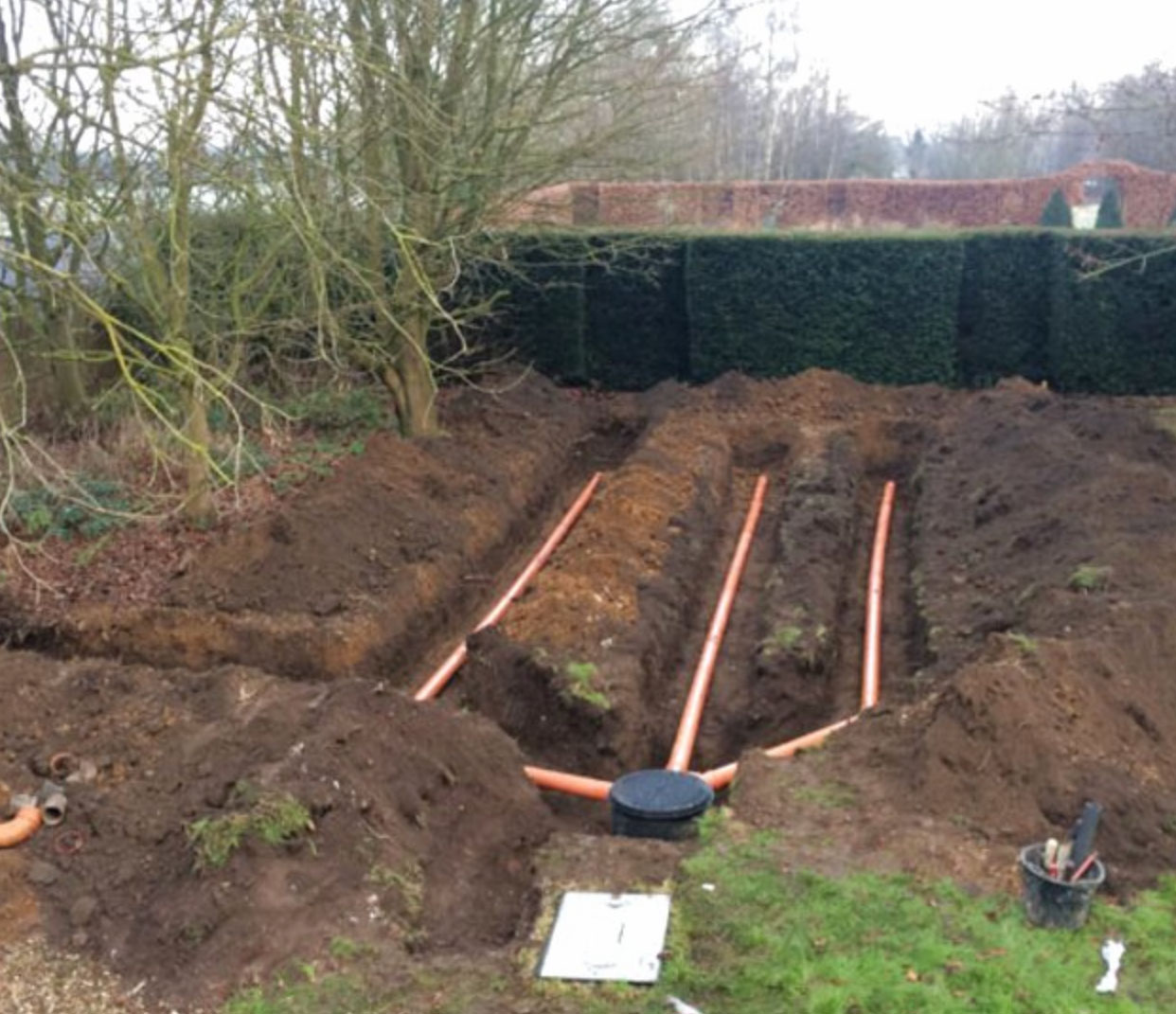 A picture of a drainage field before being covered over with soil.