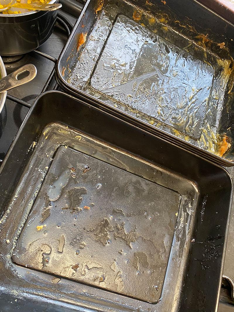 Baking trays covered in fat from what has been cooked.