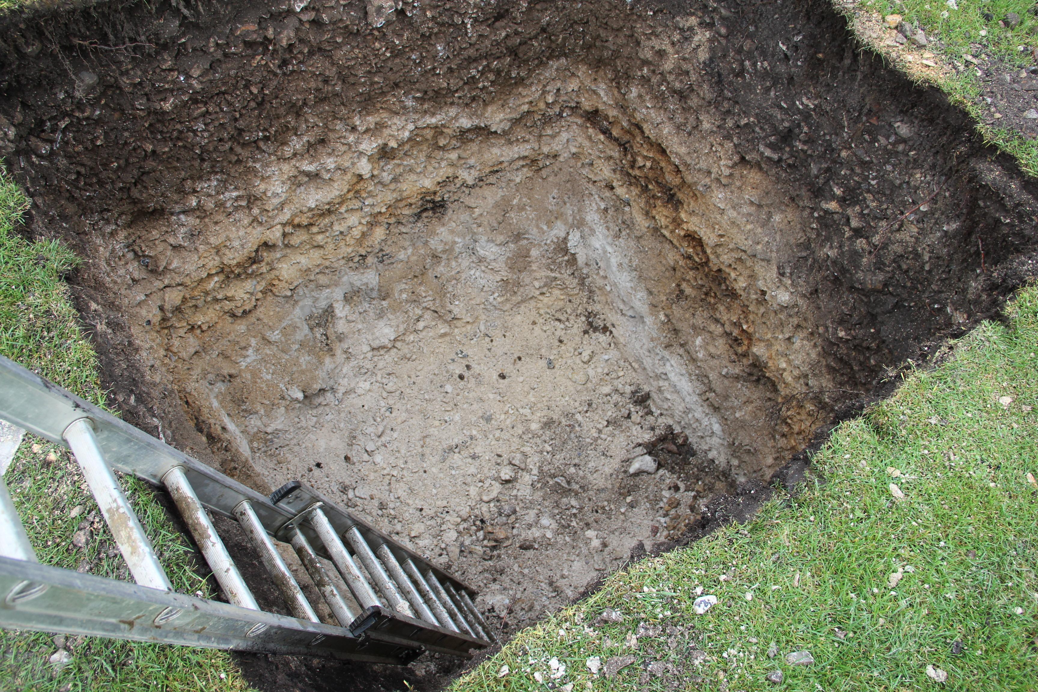 A hole dug to determine the porosity of the ground for a drainage field.