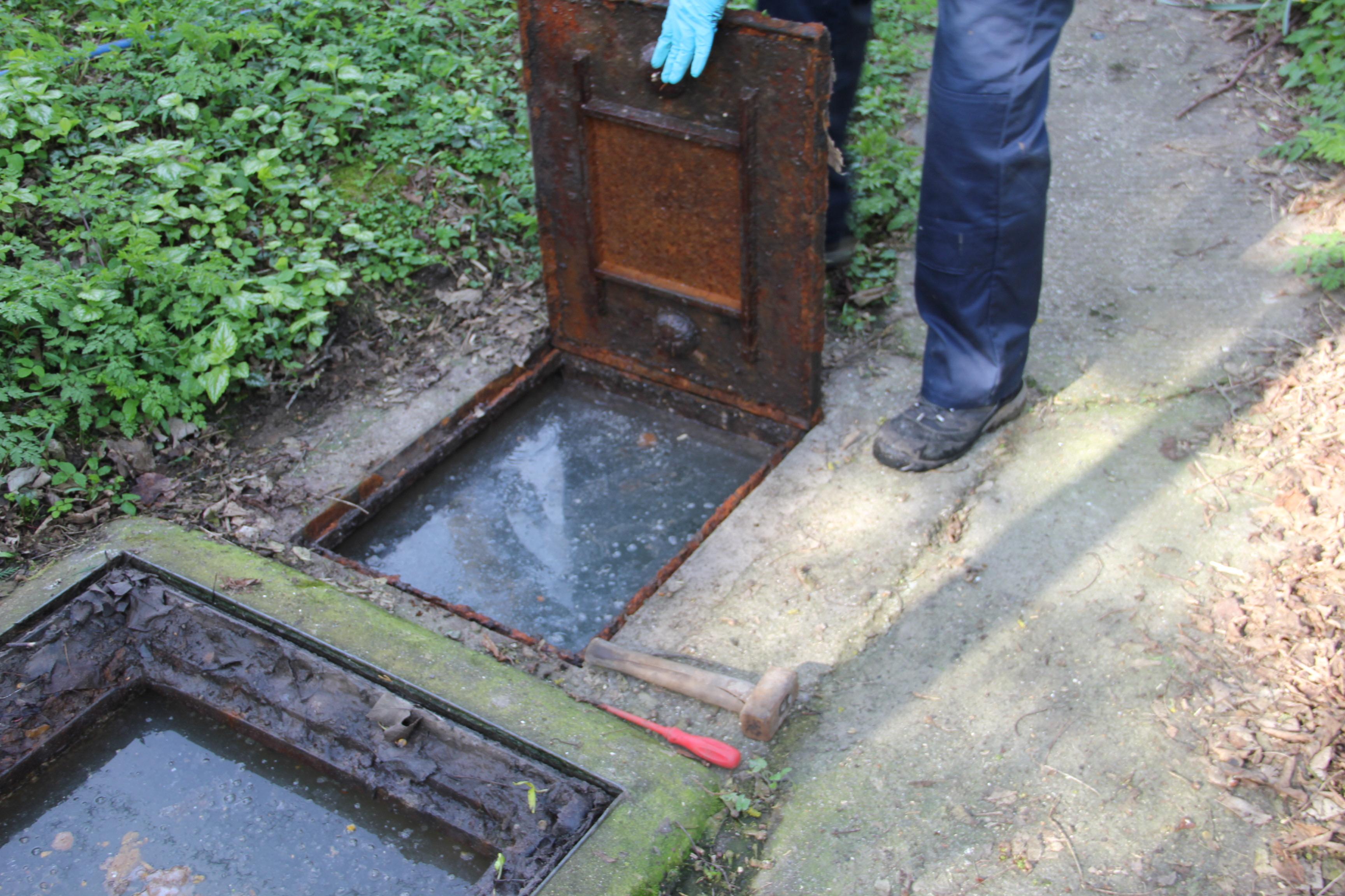 A picture of a septic tank inspection chamber with the covers lifted to empty.