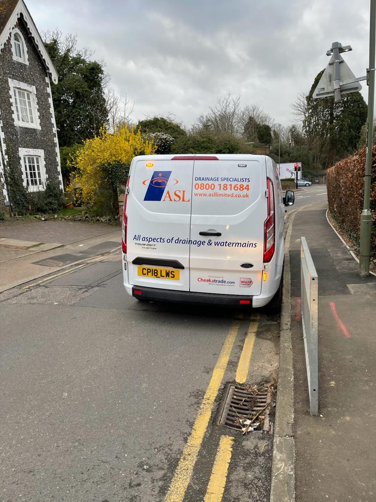 This is a photo of an ASL Limited van backed up to the road gully drain it is going to clear and clean as part of a routine maintenance.