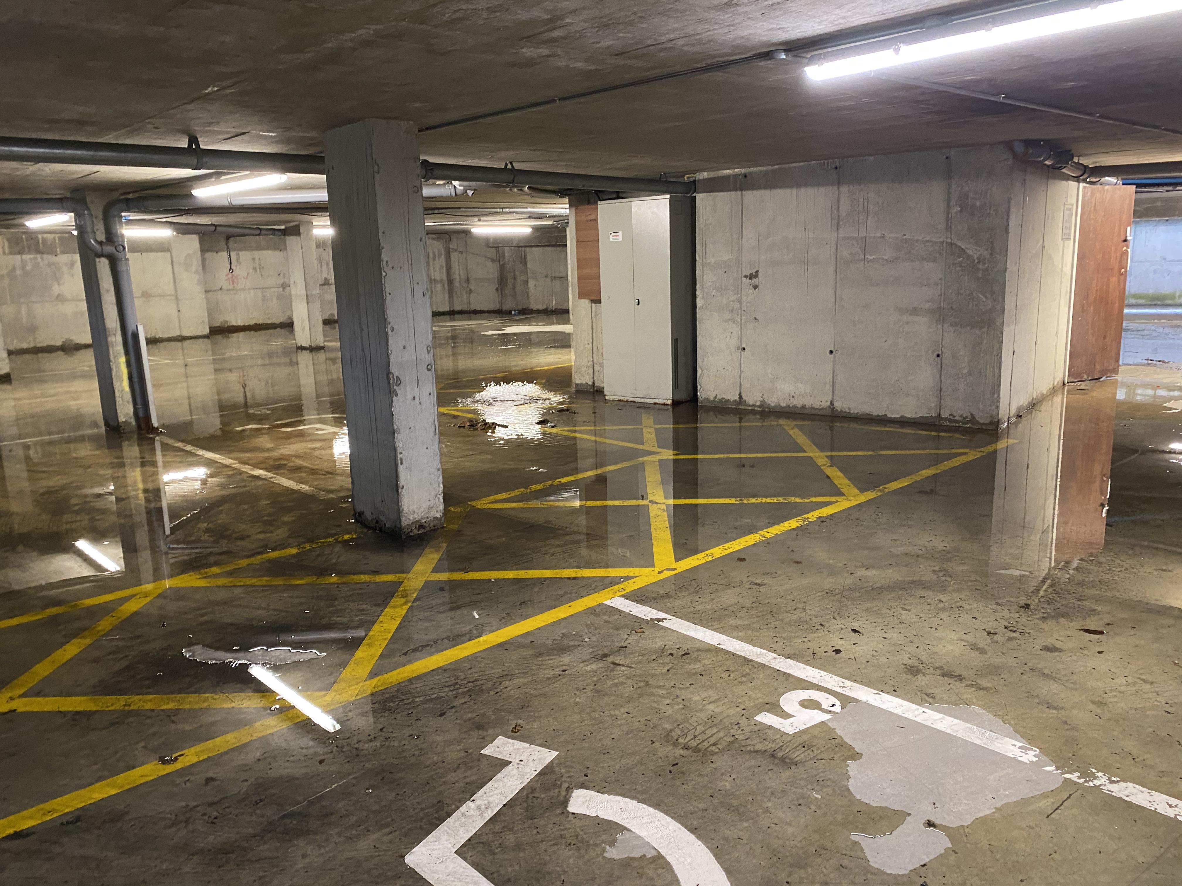 A flooded carpark due to blocked gully drains.