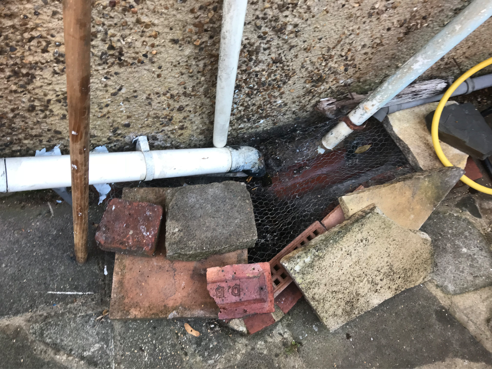 image of a rainwater drain at the side of a house