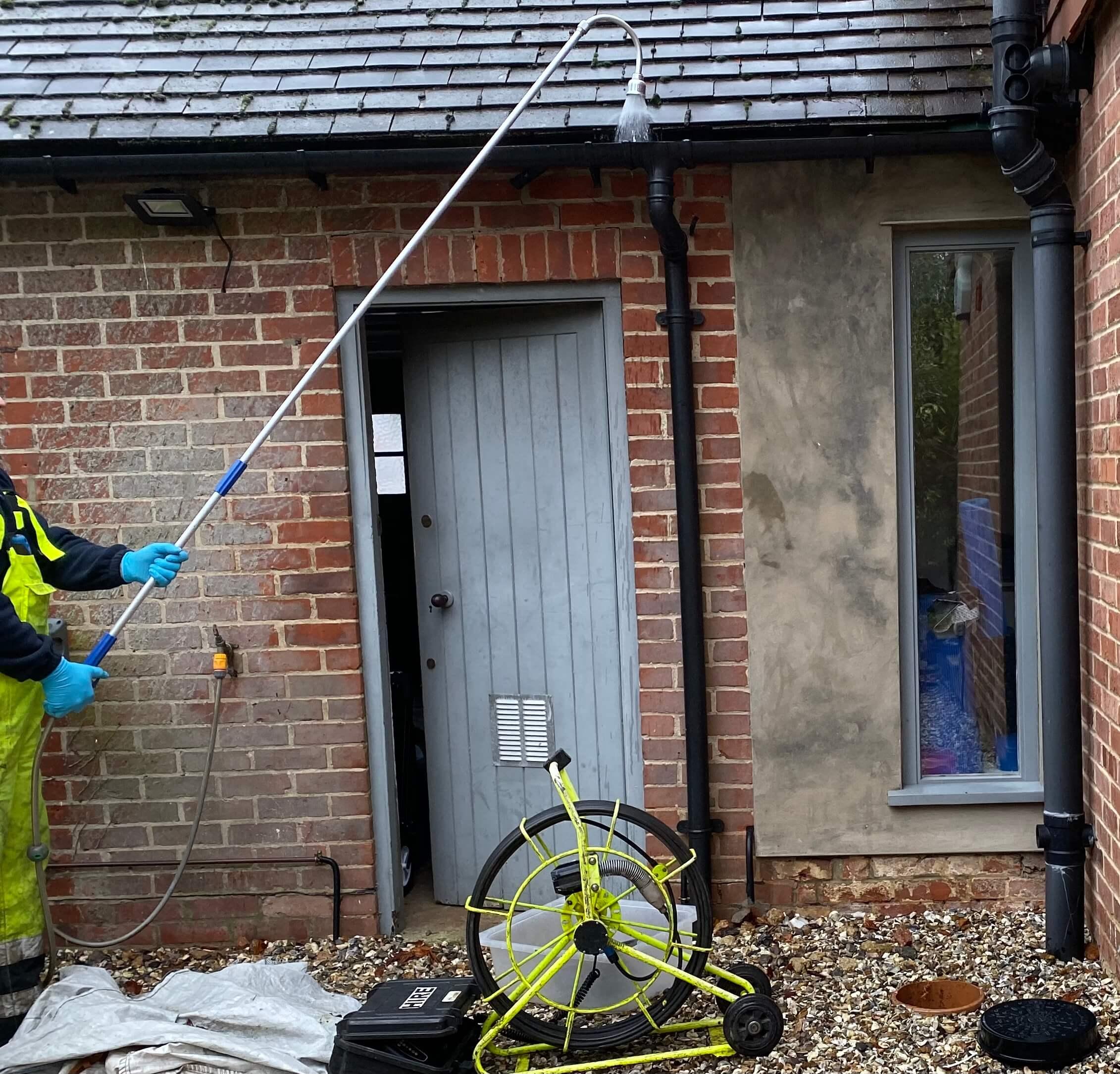 An image of one of the ASL Limited team jetting the gutter of a private home with a pole jet.