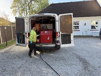 This is a photo of a jetting van with the doors open showing the insides mechanism. We are seeing a metal box with hoses attached.