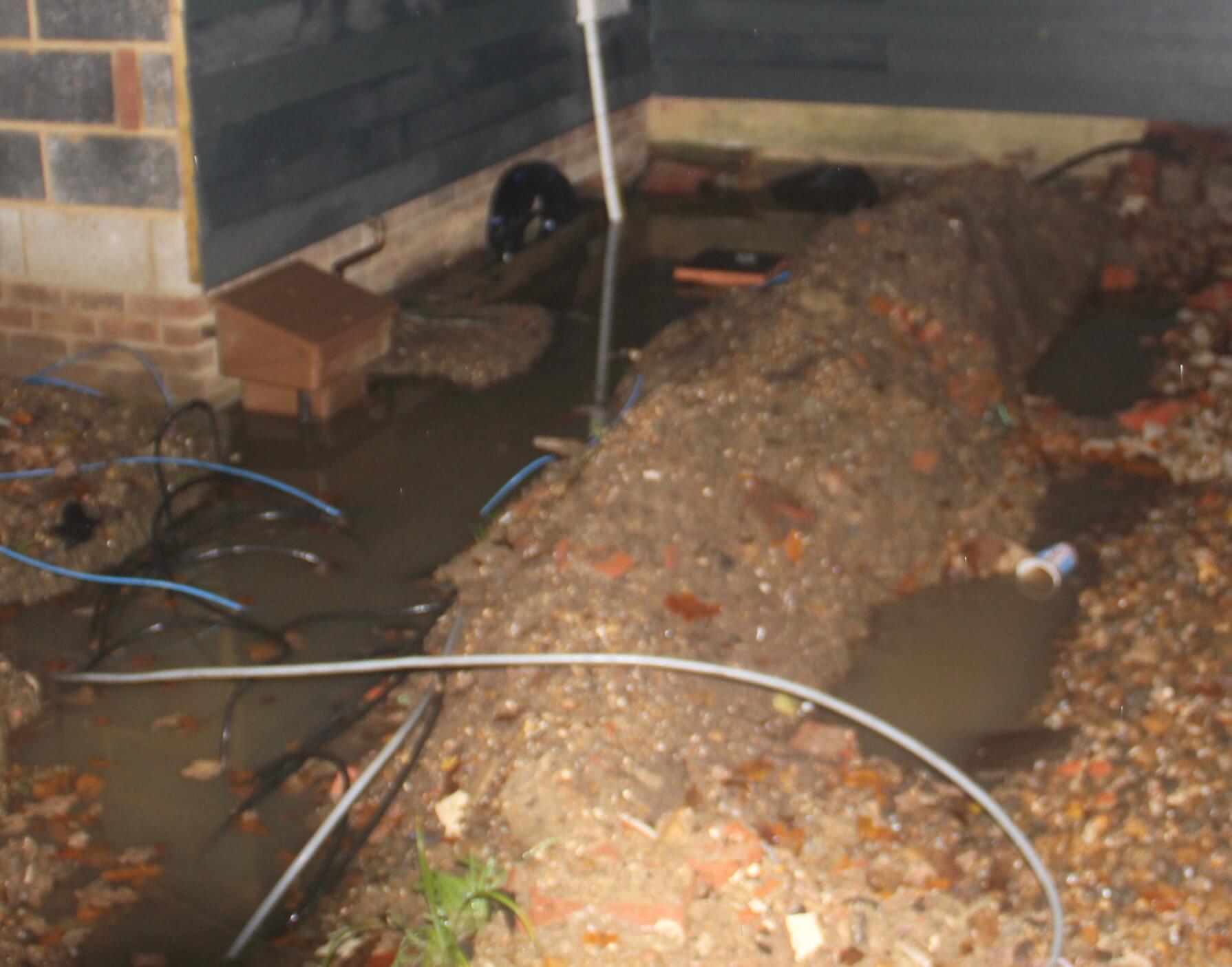 An image of a utility trench ponding alongside a house.