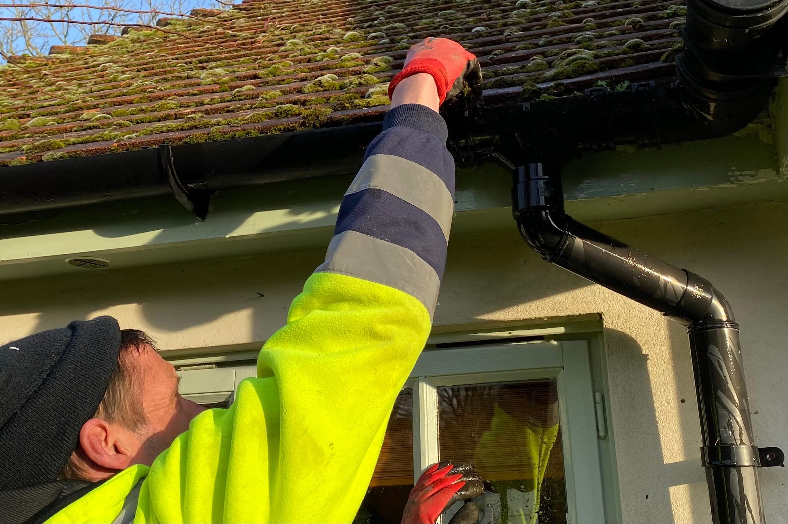 An image of one of the ASL Limited team checking the guttering of a domestic property in Guildford, Surrey