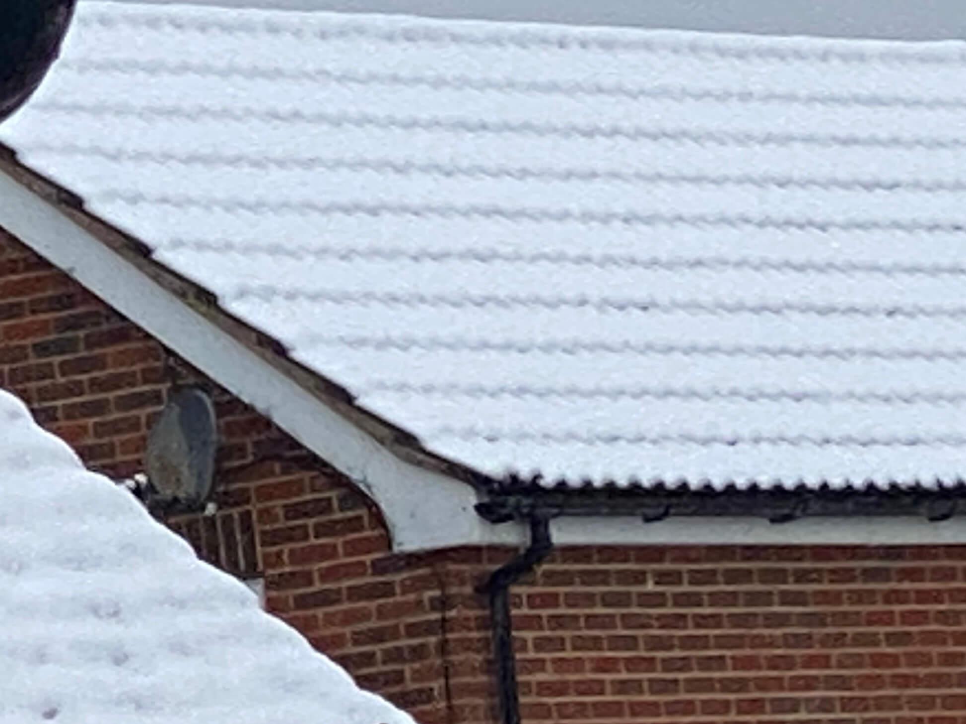 This is an image of a house roof covered in snow to depict winter and cold temperatures causing problems in drainage